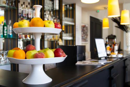 a three tiered fruit display on a counter in a bar at Hotel Le Renoir in Sarlat-la-Canéda