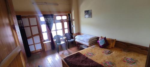 a living room with a couch and a chair and a door at Ritu Raj Home Stay & Cafe in Malther