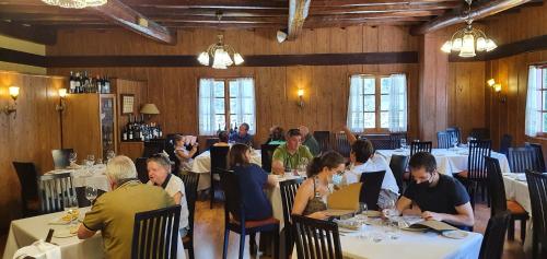 a group of people sitting at tables in a restaurant at Hotel Molina Real in Molinaseca