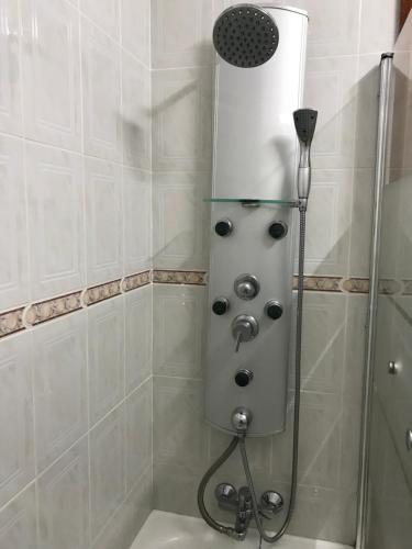 een douche met een douchekop in de badkamer bij My Little Beach House in Praia da Barra