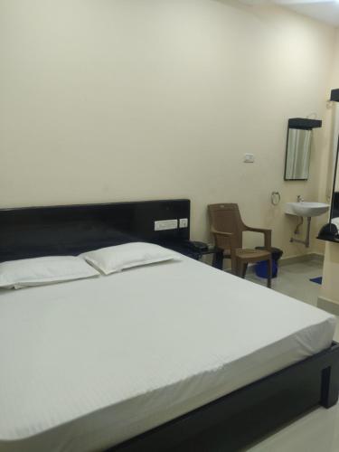Una cama o camas en una habitación de SRI VIGNESH RESIDENCY