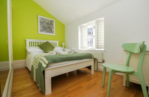 a green bedroom with a bed and a table at Kemp Town House - Parking - by Brighton Holiday Lets in Brighton & Hove