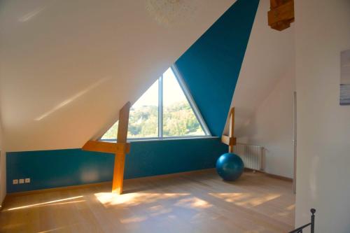 Cette chambre est dotée d'un mur bleu et d'une grande fenêtre. dans l'établissement Villa Panorama, vue Mer et Falaises d exception, à Étretat