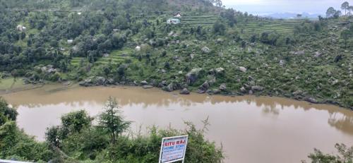 a view of a river with a sign in front of it at Ritu Raj Home Stay & Cafe in Malther