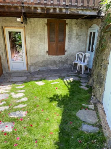 a patio with a chair and a door and grass at Studio Huguette in Courchevel