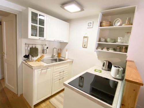 Elle comprend une petite cuisine avec des placards blancs et un évier. dans l'établissement Casa dolce Courmayeur cir0009, à Courmayeur