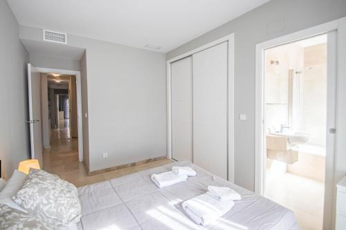 a white room with a bed and a bathroom at Recogidas Apartment 23 in Granada