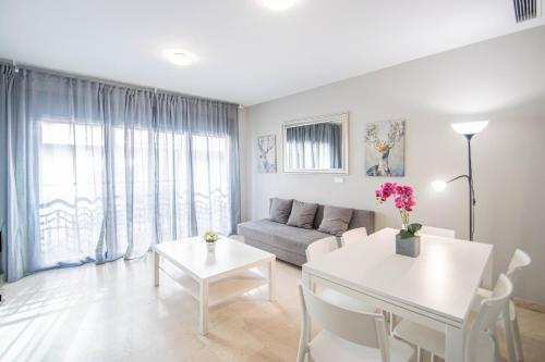 sala de estar con sofá y mesa en Recogidas Apartment by A3Rentals, en Granada