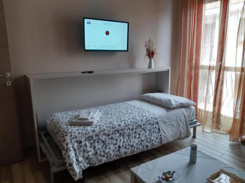 コッレーニョにあるAppartamento Sophiaのベッドルーム1室(ベッド1台、壁掛け薄型テレビ付)
