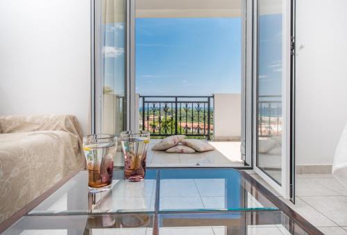 a glass table in a living room with two glasses on it at Yiannis Studios in Tsilivi