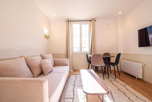 un salon avec un canapé et une table dans l'établissement Vignature residence, à Asnières-sur-Seine