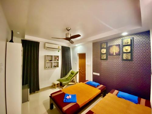 a living room with two beds and a chair at Beach Breeze and Spa in Hulhumale