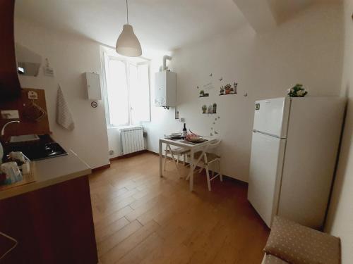 a kitchen with a refrigerator and a table and a window at Alloggio Turistico Sutri in Sutri