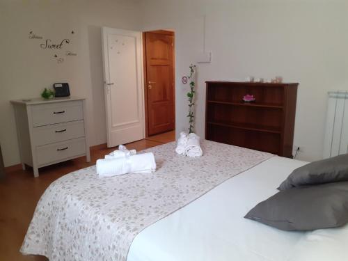 a bedroom with a white bed with towels on it at Alloggio Turistico Sutri in Sutri
