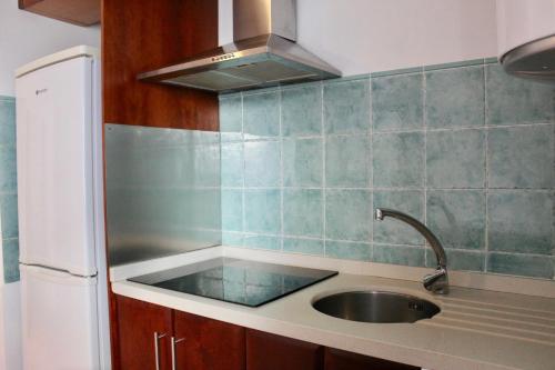 a kitchen with a sink and a refrigerator at RIBERA SUITE CÓRDOBA in Córdoba