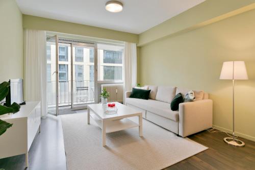 een woonkamer met een bank en een tafel bij Cosy studio in city center with sunny terrace, free NETFLIX and Wifi in Antwerpen