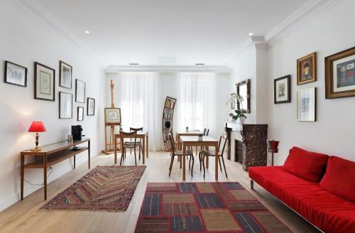 a living room with a red couch and a table at Le Clou de Louis in Bordeaux