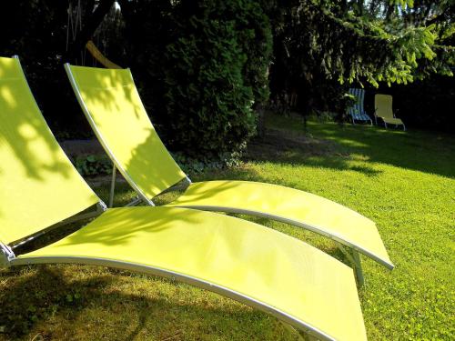 a pair of yellow chairs sitting in the grass at Gyöngyszem Vendégház in Eger