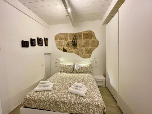 a bedroom with a bed with two towels on it at Protea House in Alghero