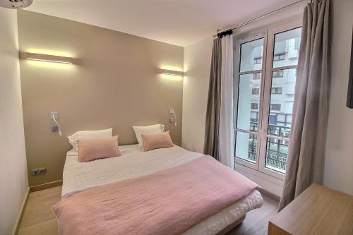 a bedroom with a large bed with pink sheets and a window at 218931 - Appartement 4 personnes à Paris in Paris
