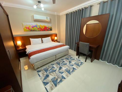 a hotel room with a bed and a desk at Royal Land Deluxe Suites رويال لاند للأجنحة الفاخرة in Duqm