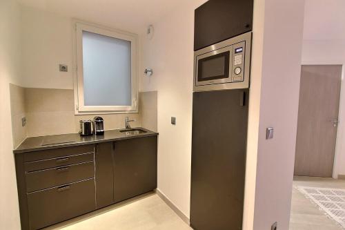 a small kitchen with a sink and a microwave at 218931 - Appartement 4 personnes à Paris in Paris