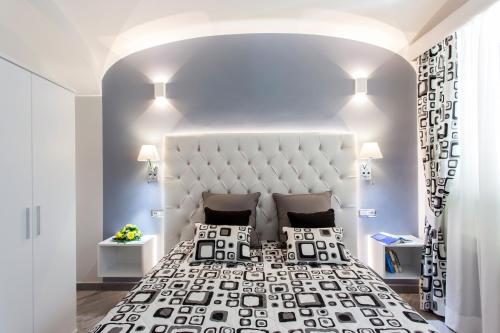 a bedroom with a large bed with a large headboard at Apartments Amalfi Design in Amalfi