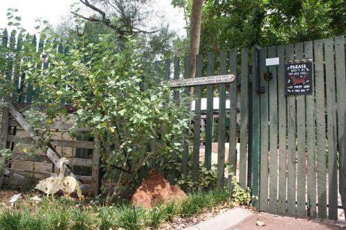 a green fence with a tree and a sign on it at Rosebridge House Bed & Breakfast Adult Retreat in Gooseberry Hill
