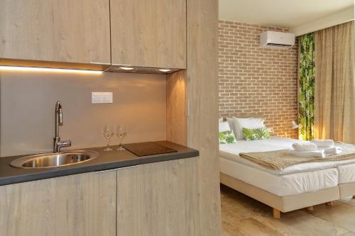 uma casa de banho com um lavatório e uma cama num quarto em The Archontariki em Ormos Panagias