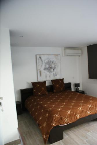 - une chambre avec un lit et une couette brune dans l'établissement Loft ravissant avec piscine, à Cagnes-sur-Mer