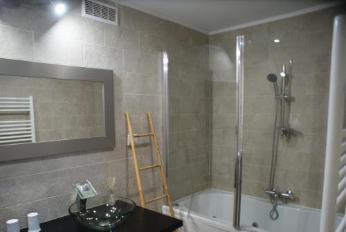 une salle de bain avec une baignoire, un lavabo et un miroir dans l'établissement Loft ravissant avec piscine, à Cagnes-sur-Mer