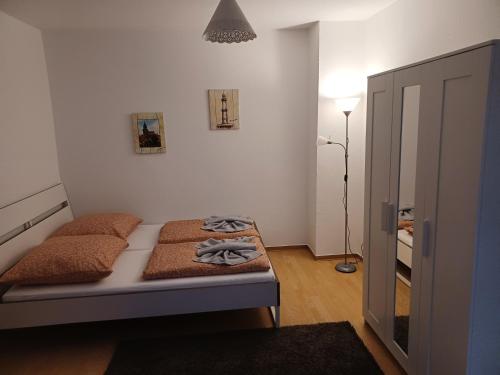 a small bedroom with a bed and a lamp at FeWo s Runde Wiese LL in Greifswald