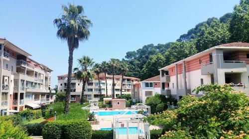 un groupe d'immeubles d'appartements avec un palmier dans l'établissement Loft ravissant avec piscine, à Cagnes-sur-Mer
