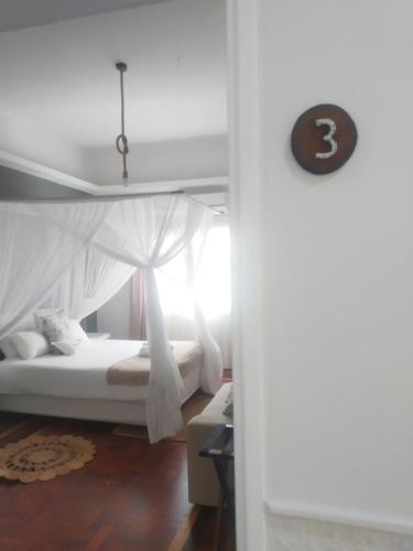 a bedroom with a bed with a canopy at Acacia Inn GuestHouse in Maputo