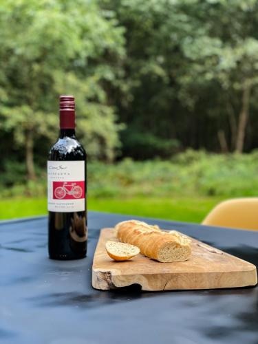 a bottle of wine and a loaf of bread on a table at Vossenbelt in Gasselte