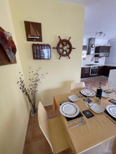 jadalnia ze stołem z talerzami i zegarem na ścianie w obiekcie apartamento anzuelo w mieście Famara