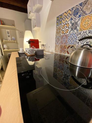 a kitchen with a counter with a pot on a wall at Domus Solarii Holiday Home in Bergamo