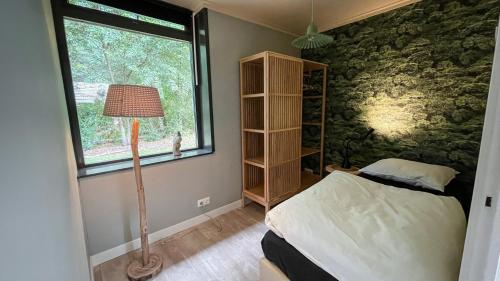 een slaapkamer met een bed en een raam bij Vossenbelt in Gasselte
