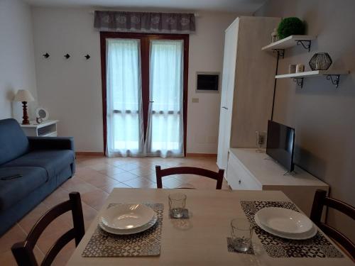 salon ze stołem i niebieską kanapą w obiekcie La casina delle Sorgentelle w mieście Bagni San Filippo