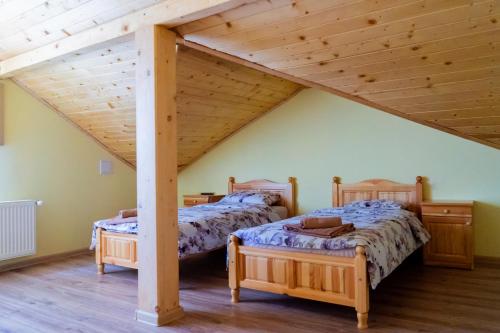 2 camas en una habitación con techos de madera en Къща Лиляна en Resilovo