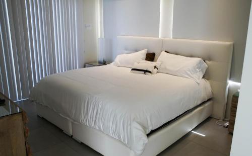 a white bed with a book on top of it at Diamante 181 Luxury home in Gold Coast 4 Bedrooms 3 Bath in Palm-Eagle Beach