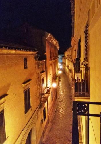 an empty street at night with buildings and lights at Cerva Bianca B&B in Santa Maria Capua Vetere