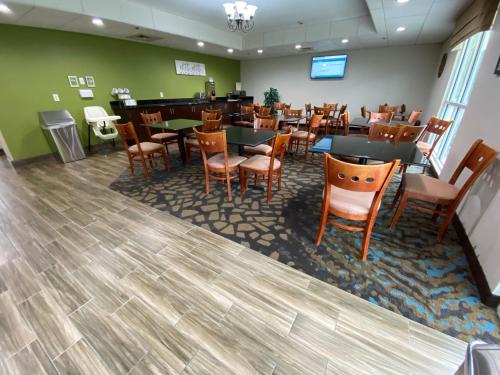 a restaurant with tables and chairs and a bar at Sleep Inn & Suites Jacksonville near Camp Lejeune in Jacksonville