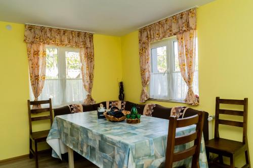a dining room with a table and two windows at Къща Лиляна in Resilovo