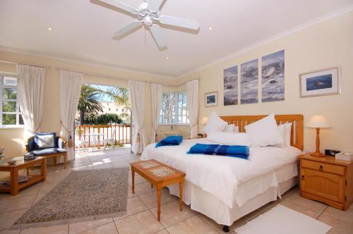 a bedroom with a large white bed with blue pillows at Anchorage Guesthouse in Port Elizabeth