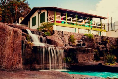 una casa con cascada frente a un edificio en Summit Lago Hotel, en Lambari