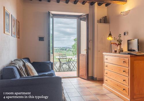 a living room with a couch and a sliding glass door at Borgo Solario in Castiglione del Lago