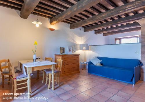 a living room with a blue couch and a table at Borgo Solario in Castiglione del Lago