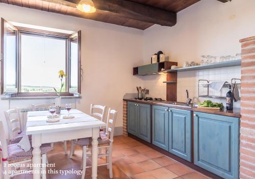a kitchen with blue cabinets and a table with chairs at Borgo Solario in Castiglione del Lago