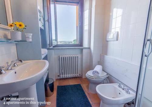 a bathroom with a sink and a toilet and a window at Borgo Solario in Castiglione del Lago